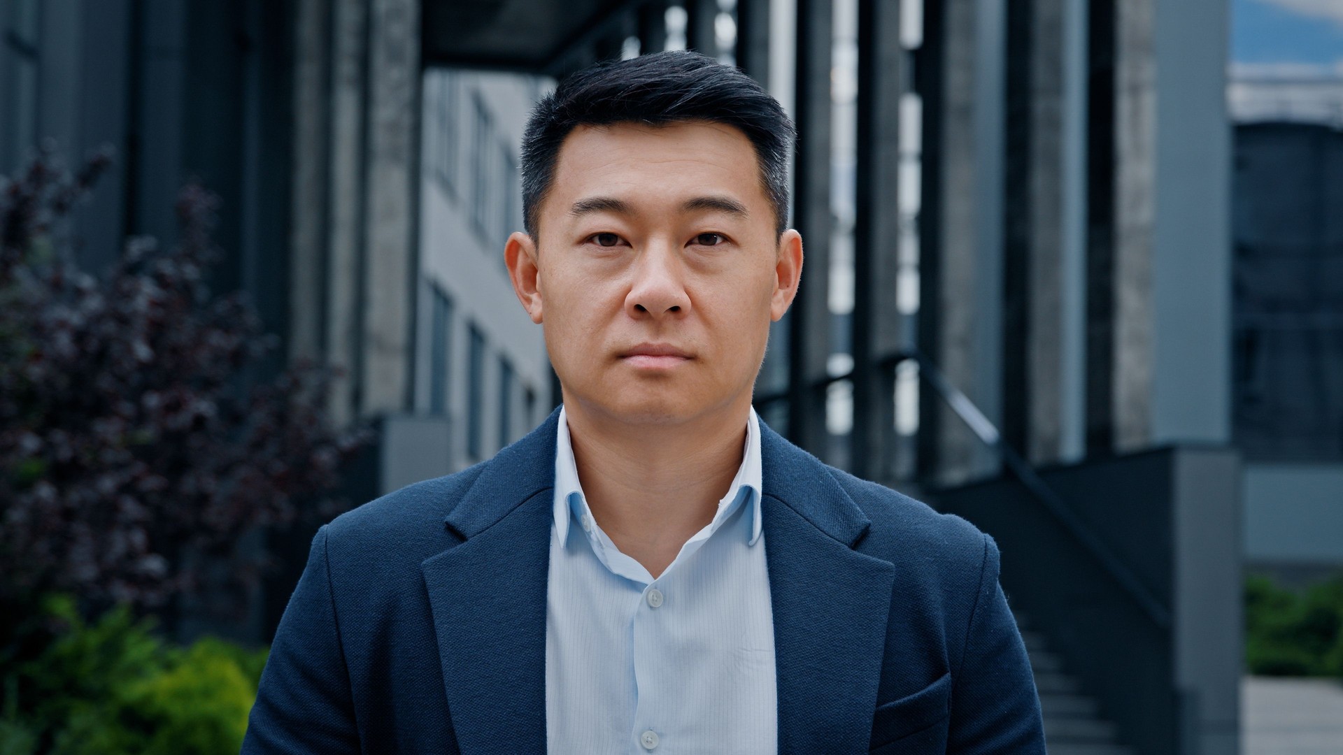 Front view close up face Asian Korean Chinese Japanese adult 40s middle-aged serious calm confident smart man businessman leader boss manager worker entrepreneur investor employer posing in city